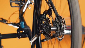 Close up of engineer using screwdriver and hex socket wrench to secure wheel on bicycle in studio background. Professional screwing bolts on bike parts, mending rear derailleur and cassette, camera A video