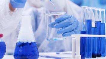 Close up of scientist taking multiple samples from a smoking blue fluid using a pipette. Scientist in protection equipment. video