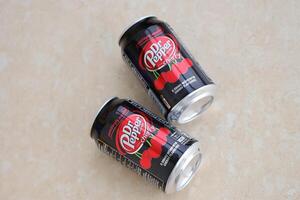 KYIV, UKRAINE - 4 MAY, 2023 Dr Pepper cherry drink black cans photo
