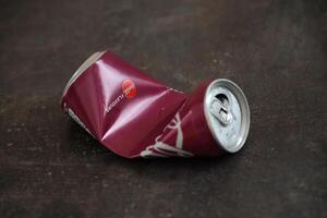 KYIV, UKRAINE - 4 MAY, 2023 Coca cola soft drink crumpled tin can with cherry flavour photo
