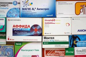 KYIV, UKRAINE - 4 MAY, 2023 Many boxes of pills and capsules stacked in pharmacy drug store photo