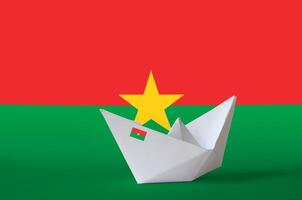 Burkina Faso flag depicted on paper origami ship closeup. Handmade arts concept photo