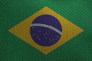 Brazil flag depicted in paint colors on old brushed metal plate or wall closeup. Textured banner on rough background photo