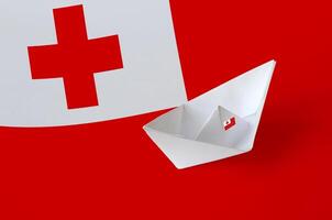 Tonga flag depicted on paper origami ship closeup. Handmade arts concept photo