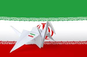 Iran flag depicted on paper origami crane wing. Handmade arts concept photo