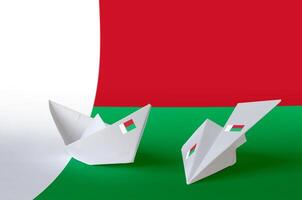 Madagascar flag depicted on paper origami airplane and boat. Handmade arts concept photo