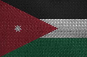 Jordan flag depicted in paint colors on old brushed metal plate or wall closeup. Textured banner on rough background photo