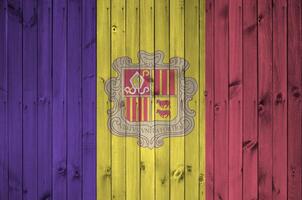 Andorra flag depicted in bright paint colors on old wooden wall. Textured banner on rough background photo
