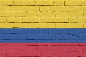 Colombia flag depicted in paint colors on old brick wall. Textured banner on big brick wall masonry background photo