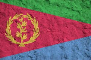 Eritrea flag depicted in bright paint colors on old relief plastering wall. Textured banner on rough background photo