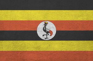 Uganda bandera representado en brillante pintar colores en antiguo alivio enlucido pared. texturizado bandera en áspero antecedentes foto