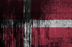Denmark flag depicted in paint colors on old and dirty oil barrel wall closeup. Textured banner on rough background photo