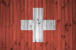 Switzerland flag depicted in bright paint colors on old wooden wall. Textured banner on rough background photo