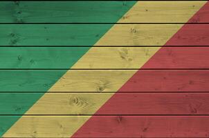 Congo flag depicted in bright paint colors on old wooden wall. Textured banner on rough background photo