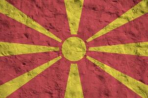 macedonia bandera representado en brillante pintar colores en antiguo alivio enlucido pared. texturizado bandera en áspero antecedentes foto