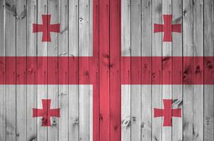Georgia flag depicted in bright paint colors on old wooden wall. Textured banner on rough background photo