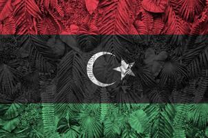 Libya flag depicted on many leafs of monstera palm trees. Trendy fashionable backdrop photo