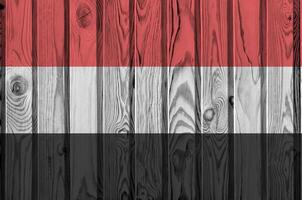 Yemen bandera representado en brillante pintar colores en antiguo de madera pared. texturizado bandera en áspero antecedentes foto
