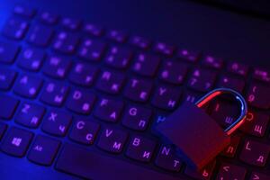 Computer security concept with a closed padlock on the keyboard. Padlock on top of a laptop keyboard. Selective focus photo