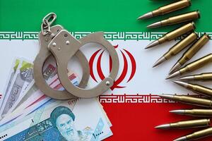 Iran flag and police handcuffs with iranian money bills rials. The concept of crime and offenses photo