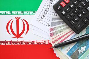 iraní negocio cálculos en mesa con iraní dinero y bolígrafo foto