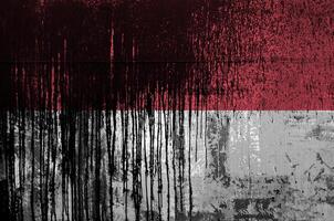 Indonesia flag depicted in paint colors on old and dirty oil barrel wall closeup. Textured banner on rough background photo