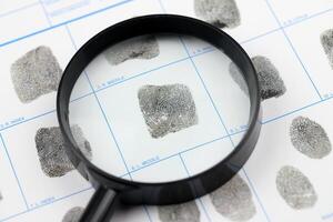 Fingerprints card police form on A4 tablet lies on office table with pen and magnifying glass photo