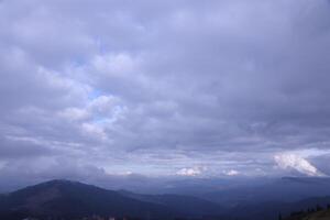 Morning view from the Dragobrat mountain peaks in Carpathian mountains, Ukraine. Cloudy and foggy landscape around Drahobrat Peaks photo