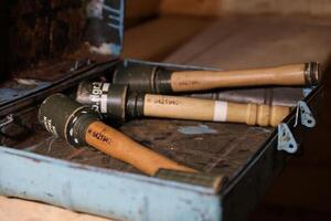 World War II fragmentation grenades stacked in a military box on wooden table in dark interior photo