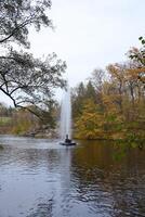 Beautiful Nature Autumn landscape with lake. Scenery view on autumn city park with golden yellow foliage in cloudy day photo