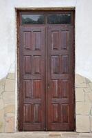 Very old solid door in brick stone wall of castle or fortress of 18th century photo