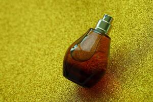 Women fragrance perfume bottle on yellow background close up. Unnamed blank sprayer bottle of perfume photo