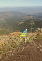 Ukrainian flag on top of Hoverla mountain in Ukraine photo