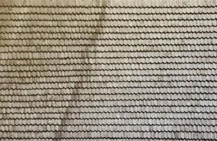 Gray wooden roof tiles background texture. A close up of old gray roof covered with wooden tiles photo