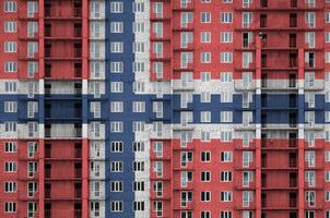 Norway flag depicted in paint colors on multi-storey residental building under construction. Textured banner on brick wall background photo