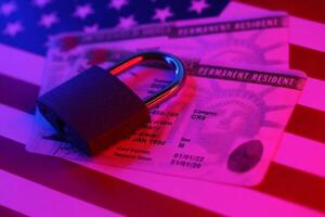 Permanent resident green card for US DV-lottery with small padlock on US flag photo