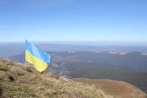 Ukrainian flag on top of Hoverla mountain in Ukraine photo