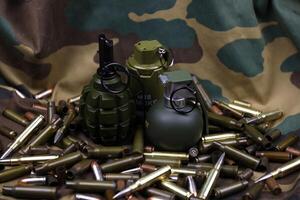 Different types of ammunition on a camouflage background. Preparing for war photo