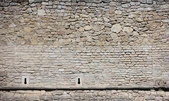 Very old brick stone wall of castle or fortress of 18th century. Full frame wall with obsolete dirty and cracked bricks photo