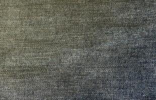 Detailed abstract texture of dark blue denim cloth. Background image of old used denim trousers fabric photo