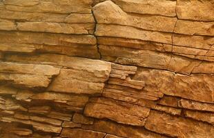 fondo de piedra de roca natural gruesa y clara. superficie frontal rugosa del acantilado minero. gran pila de piedra caliza como telón de fondo. textura de bloque de granito dañado grunge pesado foto