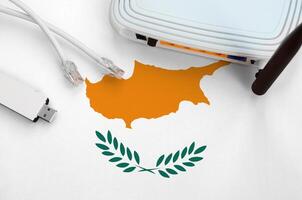 Cyprus flag depicted on table with internet rj45 cable, wireless usb wifi adapter and router. Internet connection concept photo