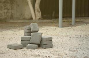 pequeño montón de losas de pasarela grises apiladas al aire libre. material para pavimentación de losas por mosaico en proceso. instalación de adoquines foto