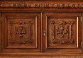Old vintage wardrobe furniture with ornamental doors and retro colors of wooden surfaces photo