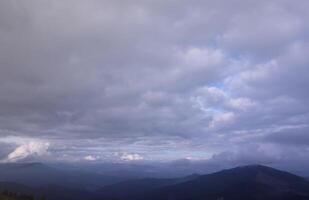 Morning view from the Dragobrat mountain peaks in Carpathian mountains, Ukraine. Cloudy and foggy landscape around Drahobrat Peaks photo