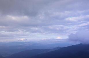 Morning view from the Dragobrat mountain peaks in Carpathian mountains, Ukraine. Cloudy and foggy landscape around Drahobrat Peaks photo