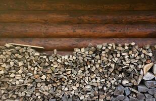 leña apilado cerca el de madera pared de antiguo cabaña. muchos Cortado registros de leña foto