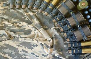 Ukrainian army fabric and machine gun belt shells lies on ukrainian pixeled military camouflage photo