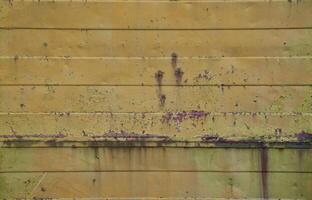 Texture of an old orange metal wall with significant damage from exposure to unfavorable weather conditions and dampness photo