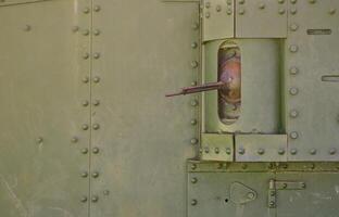 The texture of the wall of the tank, made of metal and reinforced with a multitude of bolts and rivets. Images of the covering of a combat vehicle from the Second World War with a guided machine gun photo